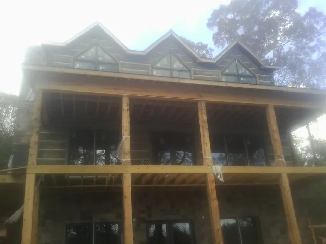 Dormers and porch framing on a large log home under construction — Roof Coating work by our crew in Ellenville