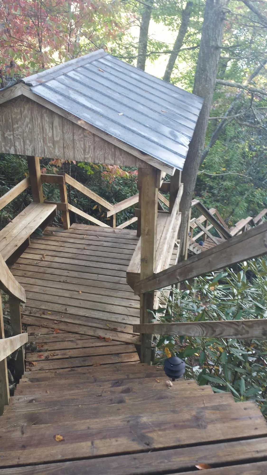 Metal roofed shelter over wooden steps on a wooded walkway — Skylight Repair & Installation work by our crew in Ellenville